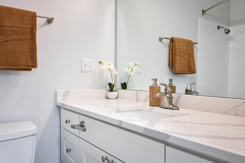 a white bathroom with a sink and a mirror